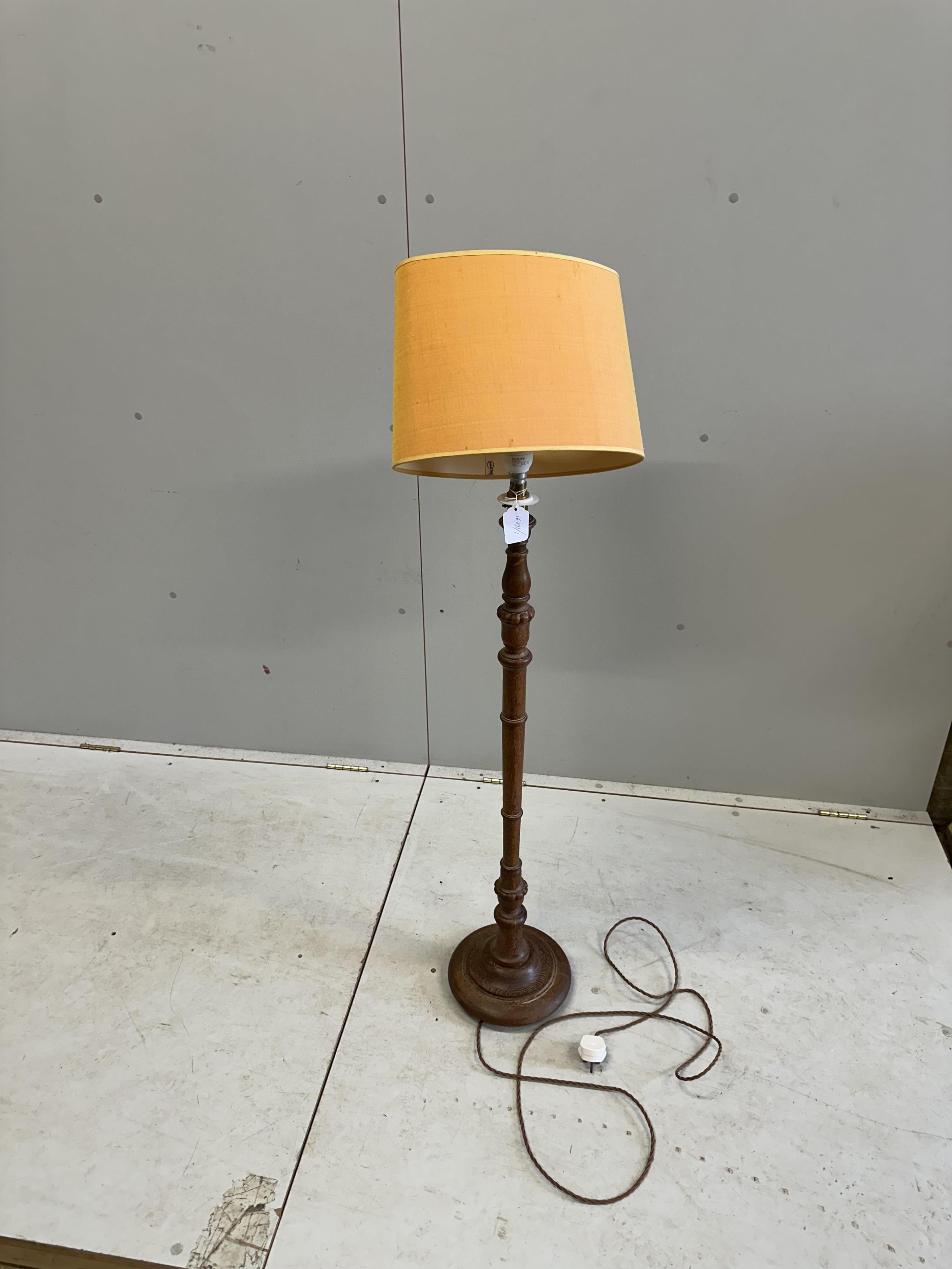 A 1930's turned oak standard lamp, height 97cm plus shade. Condition - good